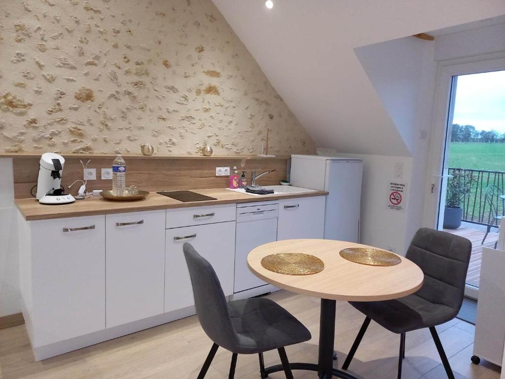 cocina con mesa, mesa y sillas en La Suite Etoilée - Balnéo privative, en Courgains