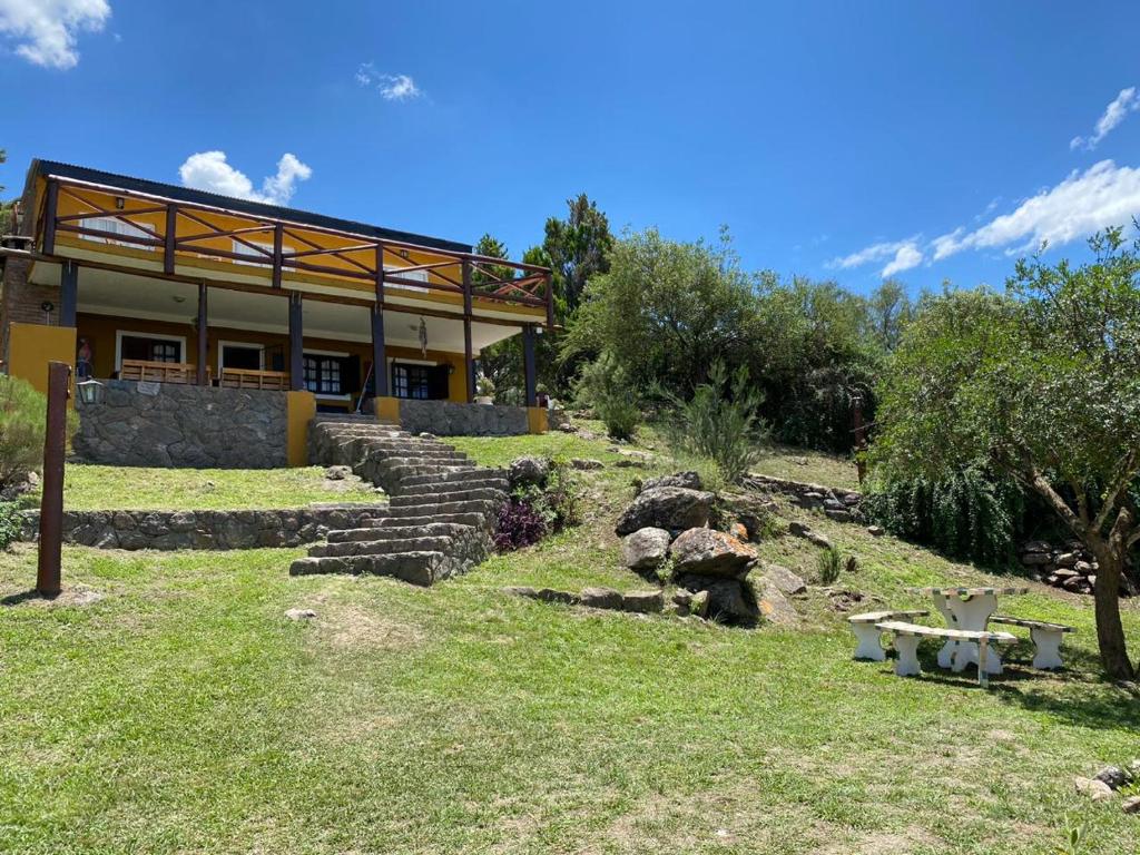 un bâtiment avec des marches en pierre et un banc dans l'herbe dans l'établissement Buena Vista Icho Cruz, à Villa Icho Cruz