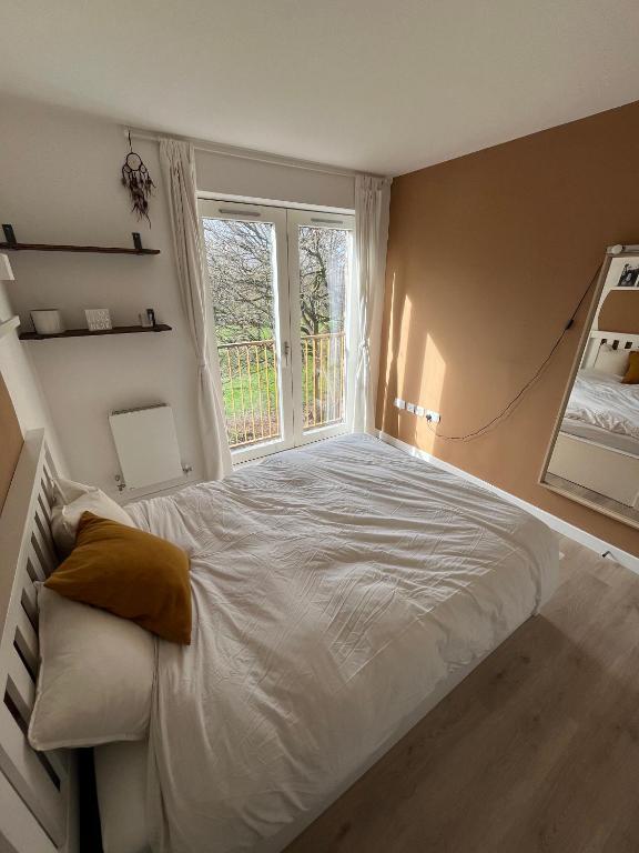 a bedroom with a large bed with a window at The Nest Tottenham - cosy one bed apartment in London