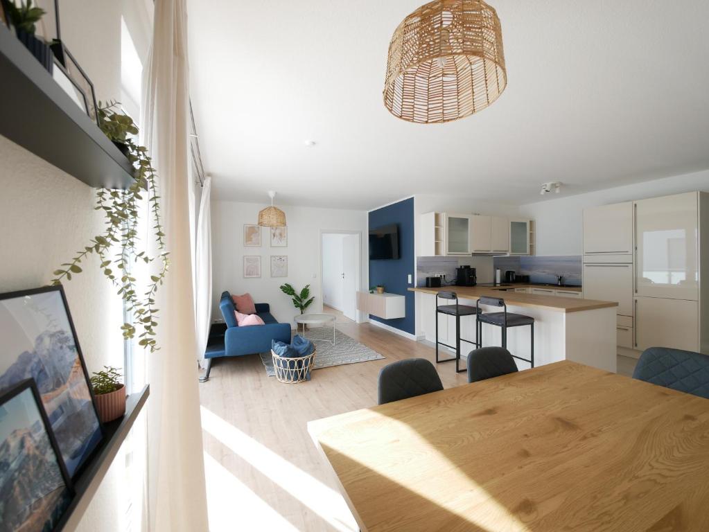 uma cozinha e sala de estar com uma mesa de madeira num quarto em 85qm, Parkplatz, zentral, großer Balkon, 2 Bäder em Paderborn