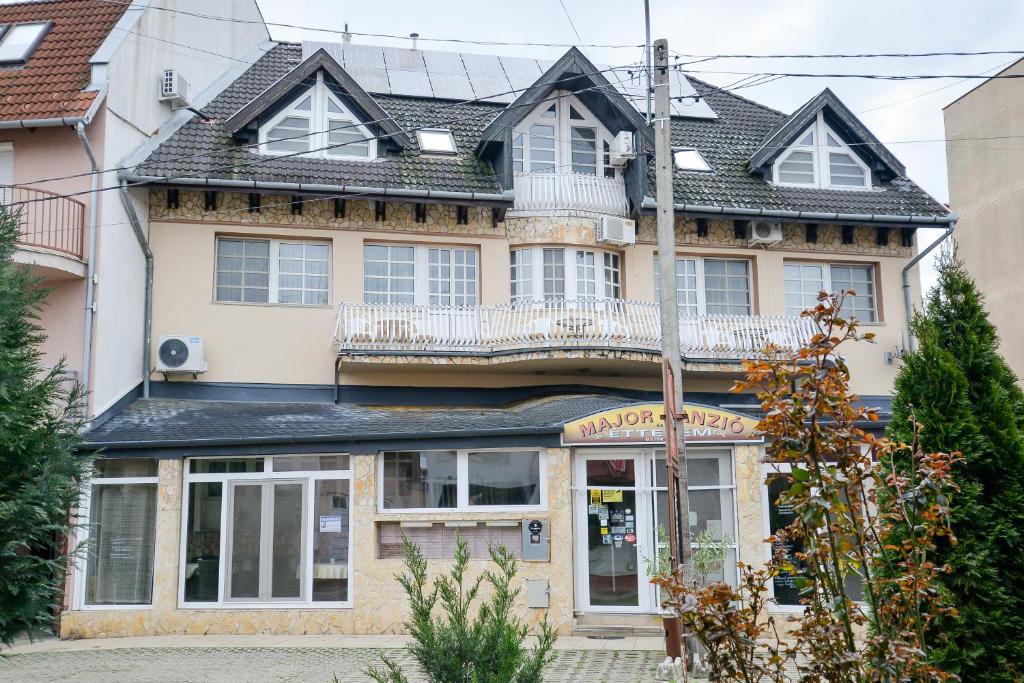 een huis met een balkon er bovenop bij Major Panzió és Étterem in Hajdúszoboszló