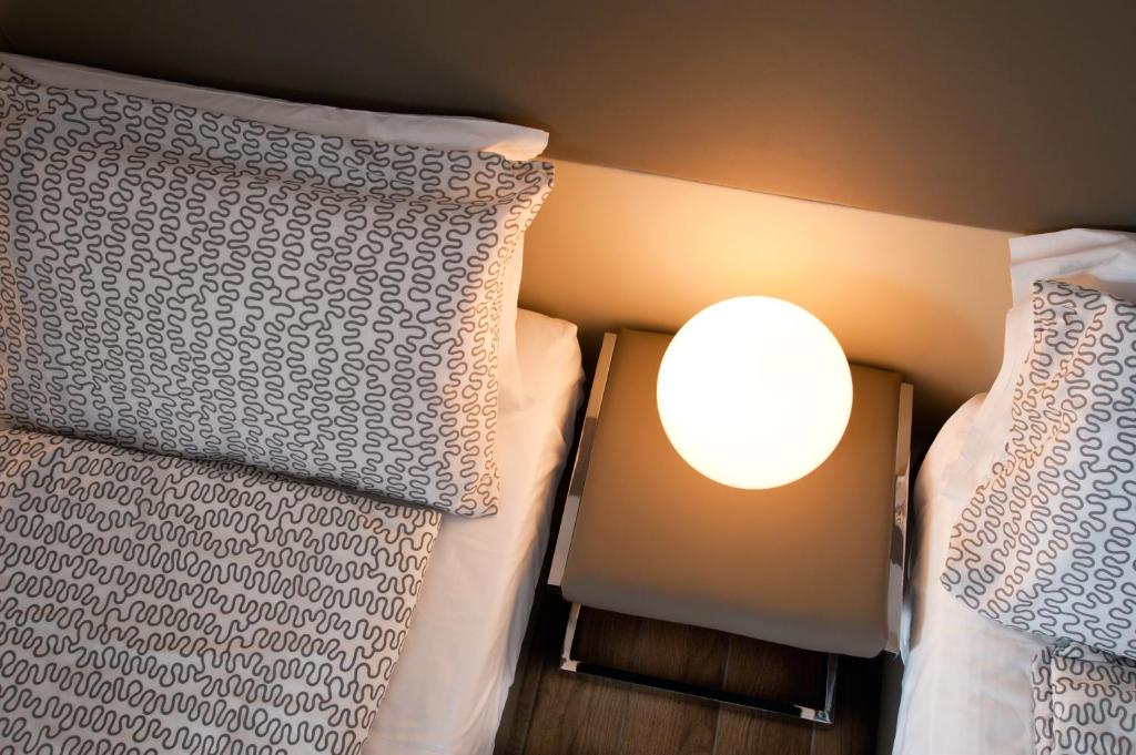 two beds next to each other with a light between them at B&B Raffaello a Mare in Montesilvano