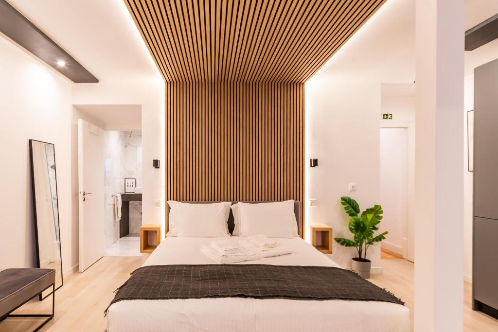 ein Schlafzimmer mit einem großen Bett mit gestreifter Wand in der Unterkunft Charming Loft in Bairro Alto - JJ Apartment`s in Lissabon