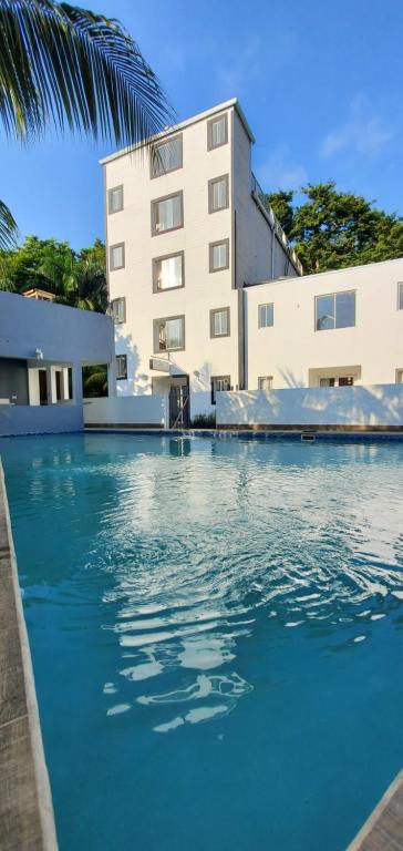 a swimming pool in front of a building at HOTEL ARRECIFE in Roatán