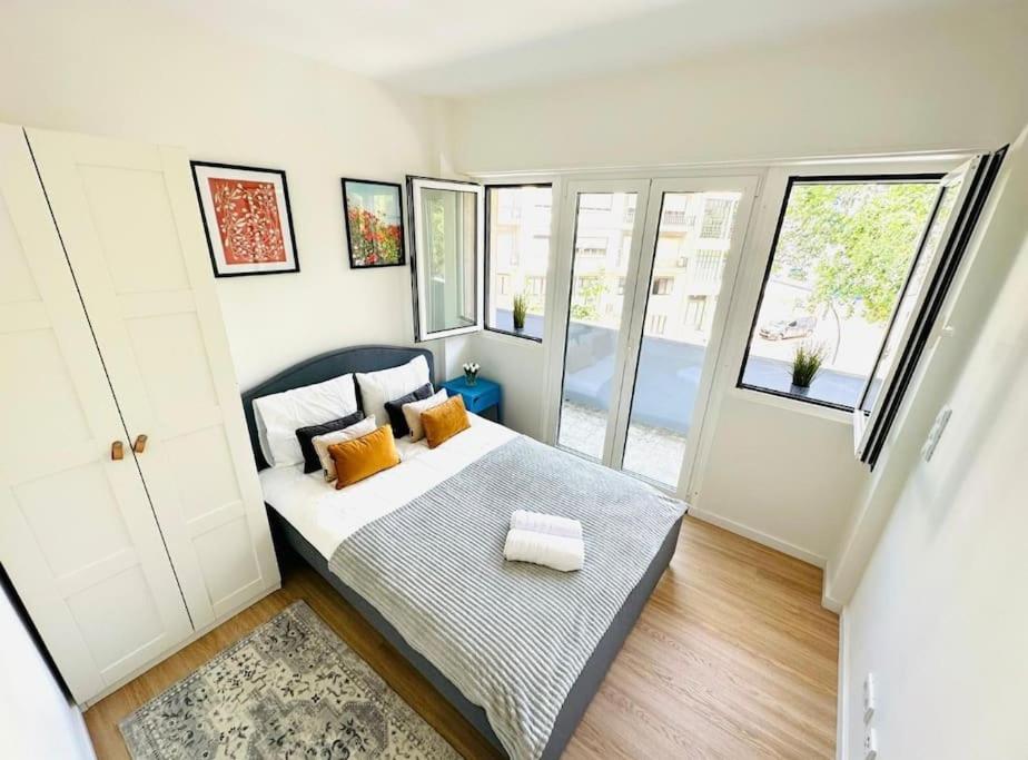 ein kleines Schlafzimmer mit einem Bett und einem Fenster in der Unterkunft Amazing Flat Perfect for Tourists in Lissabon