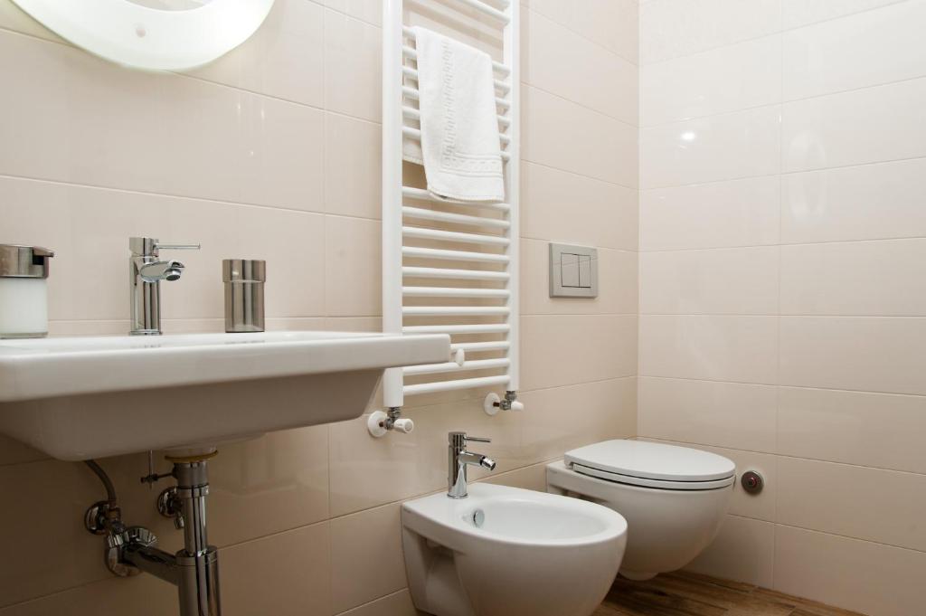 a white bathroom with a sink and a toilet at B&B Raffaello a Mare in Montesilvano