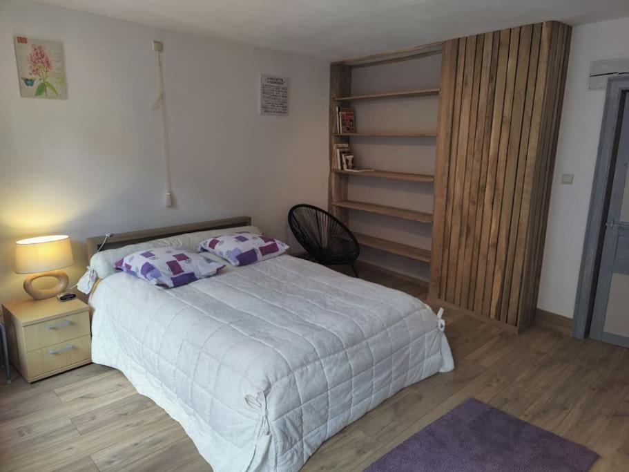 um quarto com uma cama, uma mesa de cabeceira e um armário em La pleine lune em Chimay