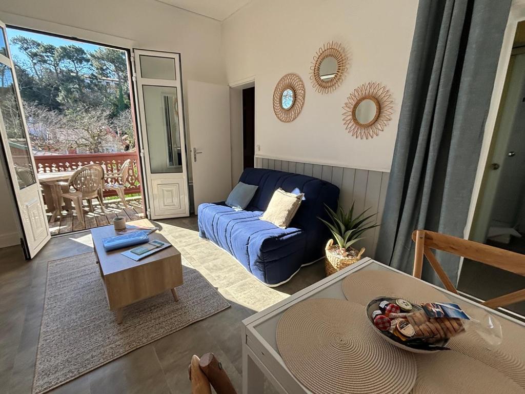 un salon avec un canapé bleu et une table dans l'établissement T2 Arcachon Vacances et Plages a 50 mètres, à Arcachon