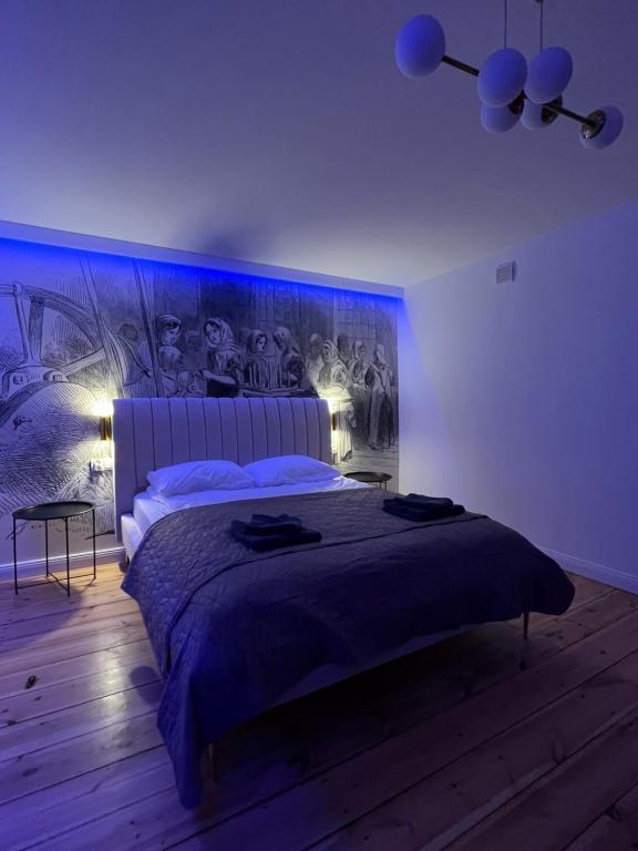 1 dormitorio con 1 cama con una pintura en la pared en Brickller Apartments by Letrent, en Żyrardów