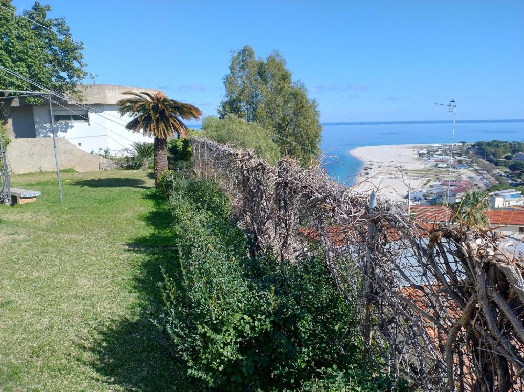 a fence with a palm tree next to a beach at Soverato con Vista in Soverato Marina