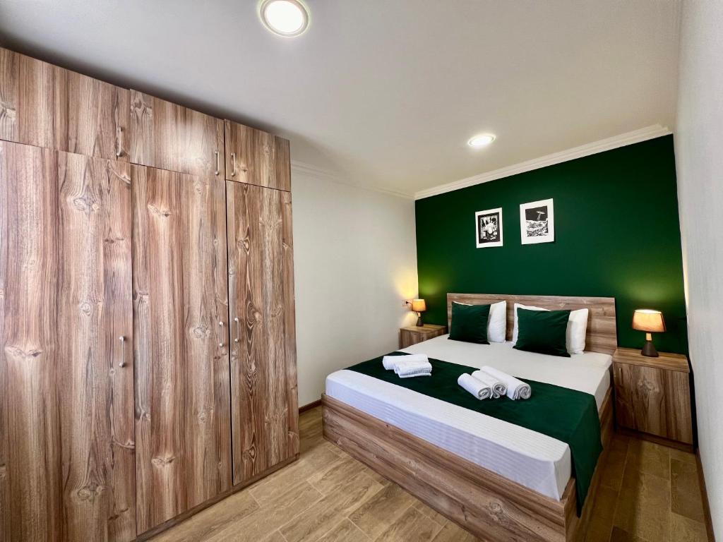 - une chambre avec un grand lit et un mur vert dans l'établissement Byurakan Villas near Kari Lake, à Byurakan
