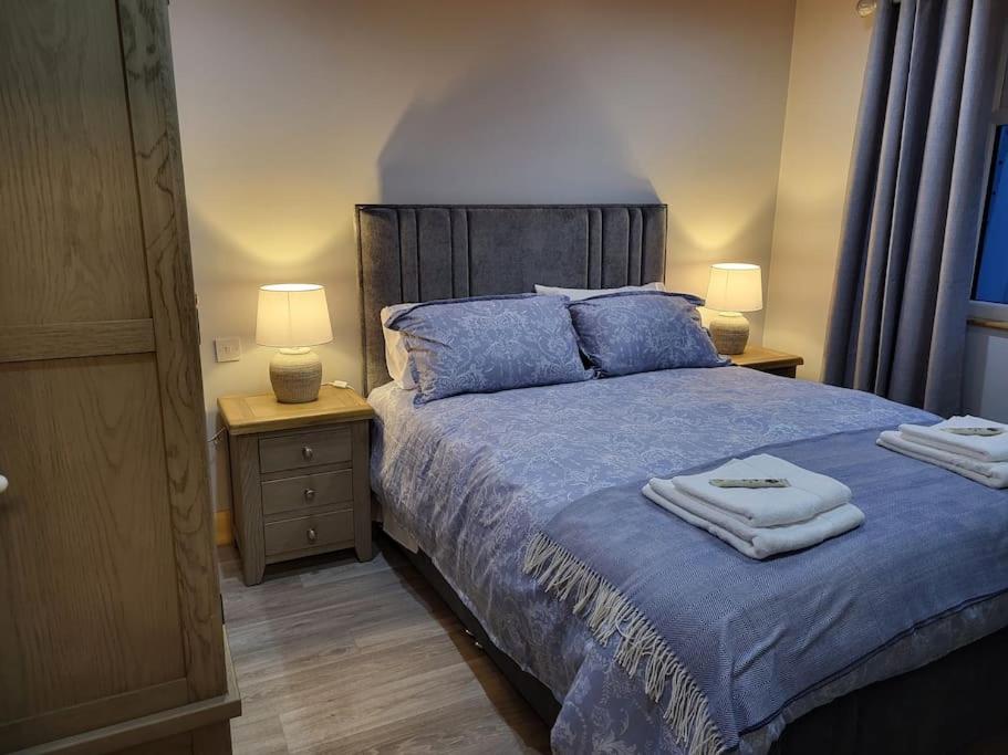 a bedroom with a blue bed with towels on it at White O'Morn Cabin in Newry