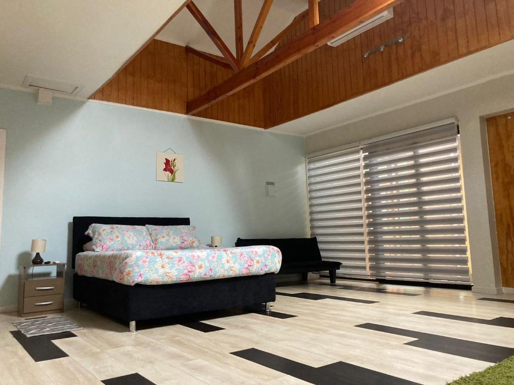 ein Schlafzimmer mit einem Bett und einem Sofa in einem Zimmer in der Unterkunft Amplia habitación con Jacuzzi in Valdivia