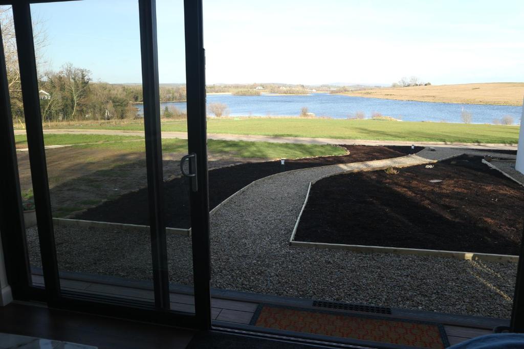 a view from a sliding glass door looking out at a golf course at LakEscape - Waterfront Self- Catering Cabins in Enniskillen