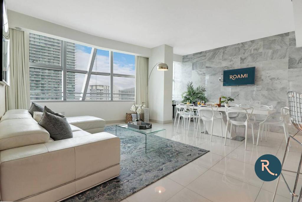 a living room with a white couch and a table at Roami at Brickell Penthouse Luxe Loft in Miami