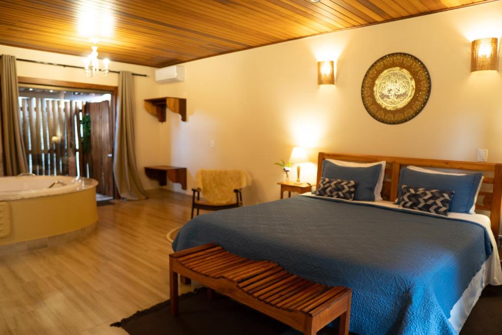 a bedroom with a bed and a tub in a room at Pousada Lua Clara in Alto Paraíso de Goiás