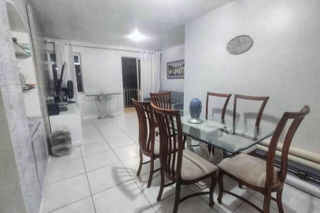 a dining room with a glass table and chairs at Espaçoso em excelente localização na Barra in Salvador