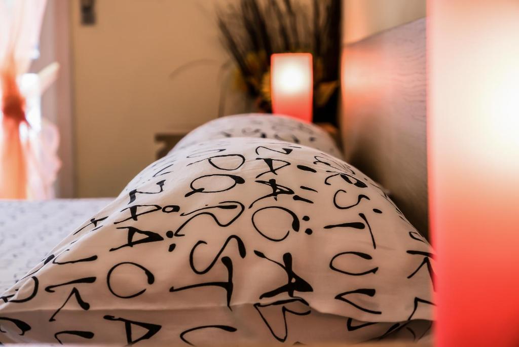 ローマにあるA Place Apartの白い枕(ベッドの上にブラックレター付)