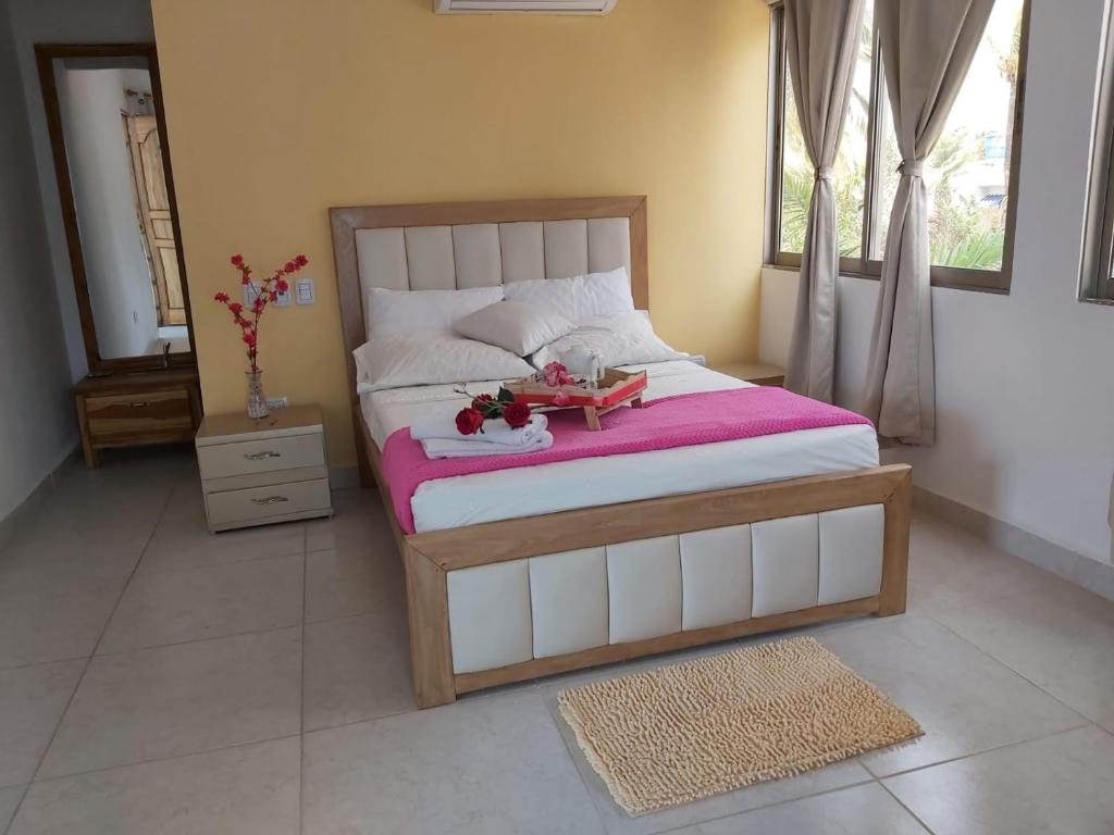 a bedroom with a bed with a doll sitting on it at Dreimar Hotel Boutique in Cartagena de Indias
