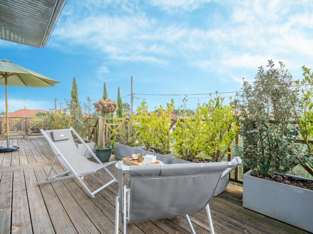 un patio avec deux chaises et une table sur une terrasse dans l'établissement Apartment Dade-3 by Interhome, à La Teste-de-Buch