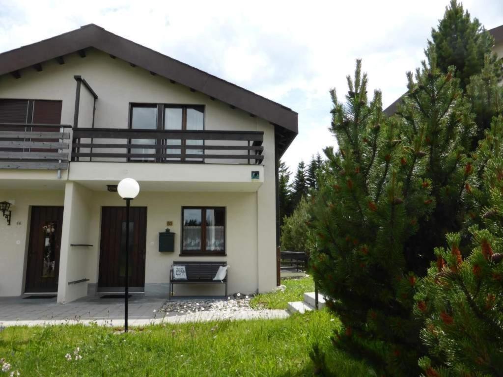 a white house with a balcony and a tree at Apartment La Schmetta 65 Quadroni by Interhome in Lenzerheide