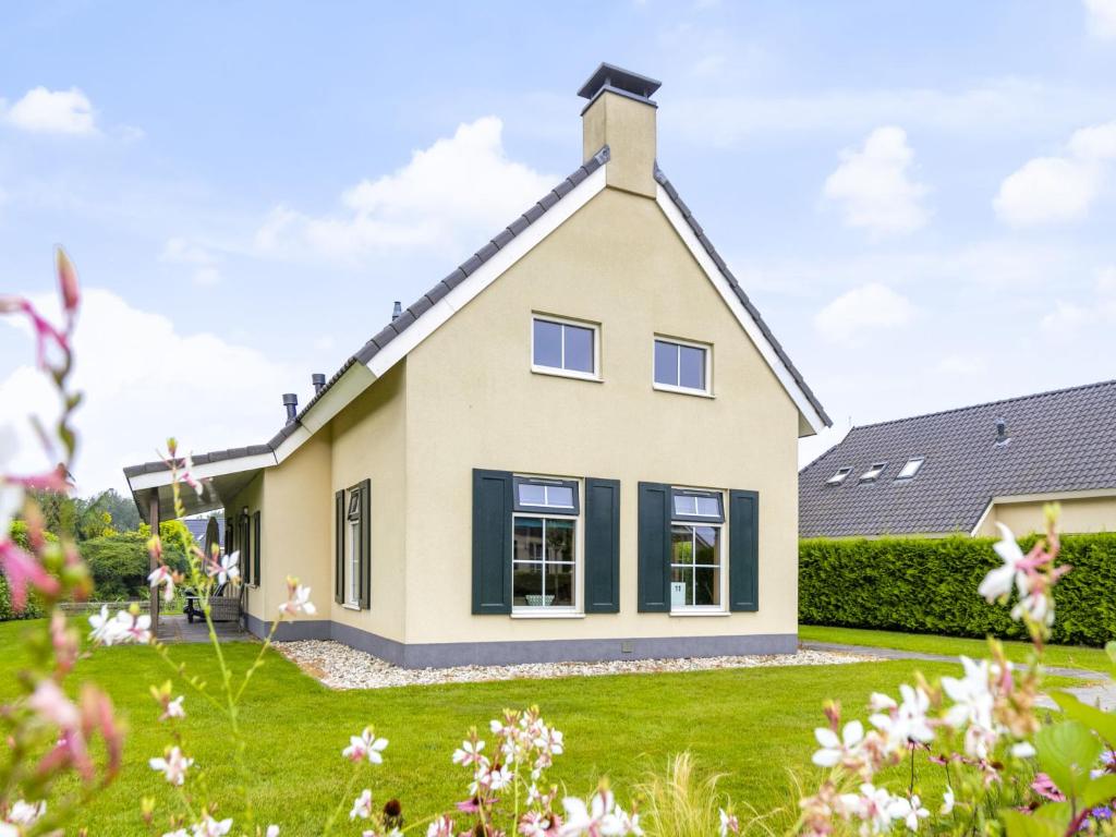 une maison avec des fenêtres noires et une cour verte dans l'établissement Holiday Home Heerd Wellness de Luxe by Interhome, à Vlagtwedde