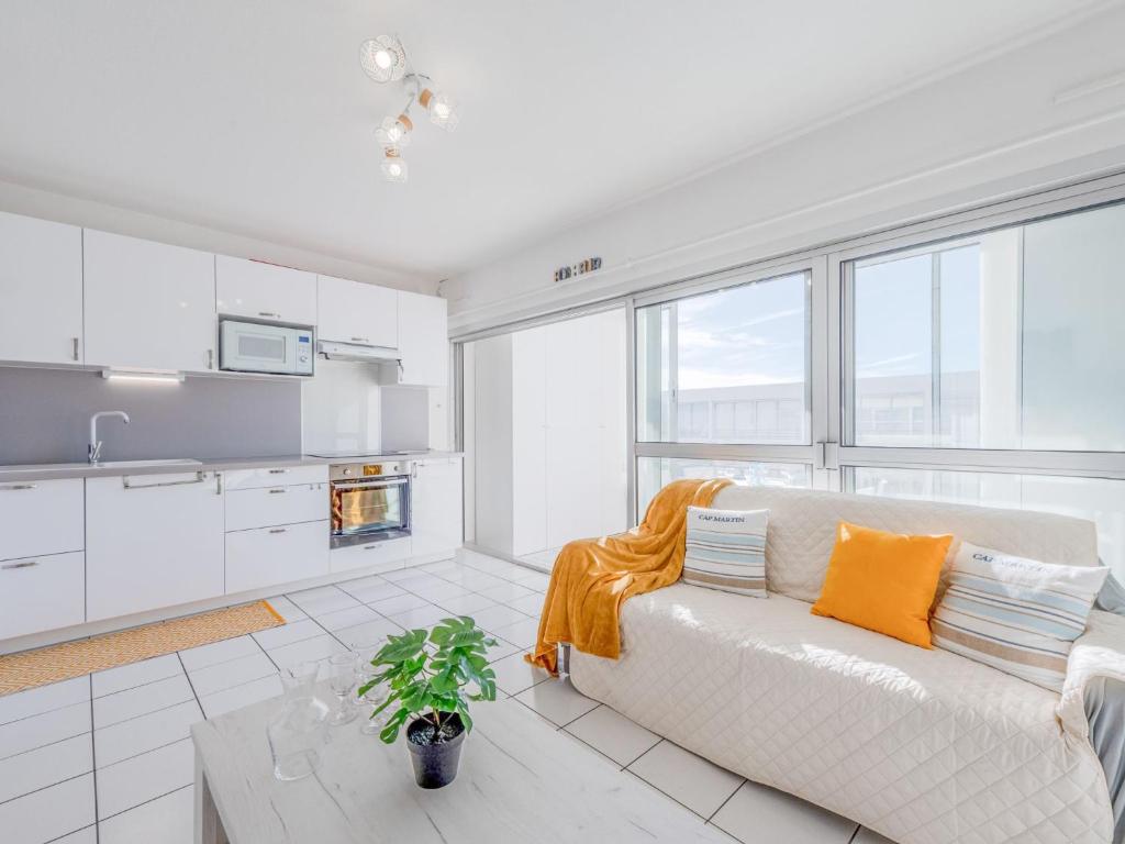 ein weißes Wohnzimmer mit einer Couch und einem Tisch in der Unterkunft Apartment Grand Bleu by Interhome in Le Barcarès