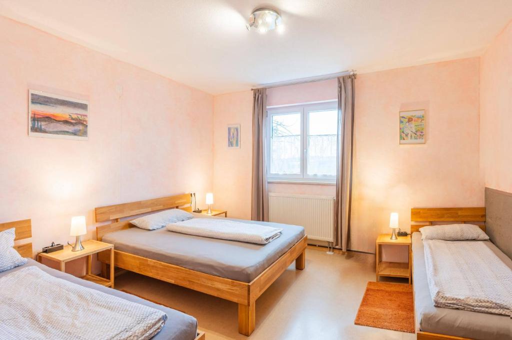 1 dormitorio con 2 camas y ventana en Ruhe auf dem Land 2 - Anni, en Aulendorf