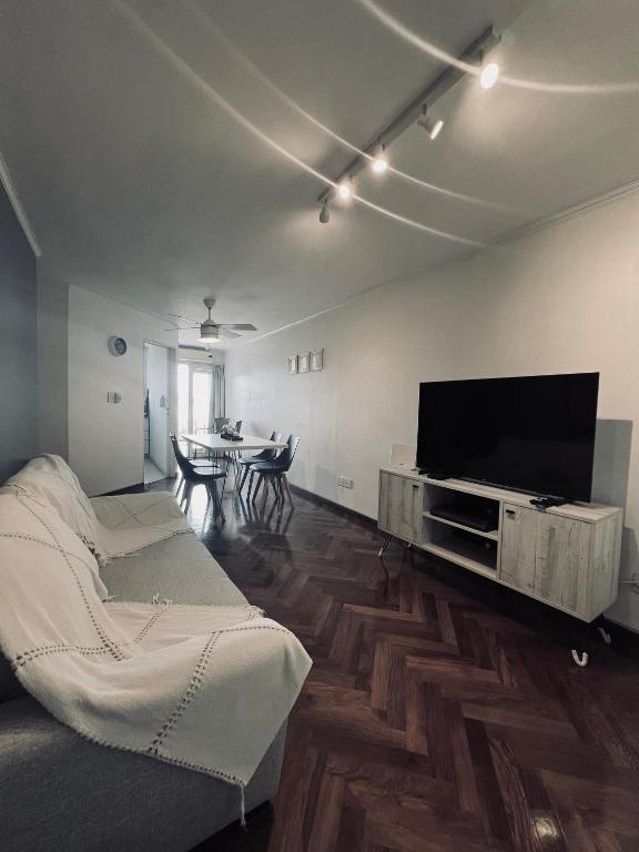 uma sala de estar com uma televisão de ecrã plano e um sofá em Moderno departamento en Nueva Córdoba em Córdoba