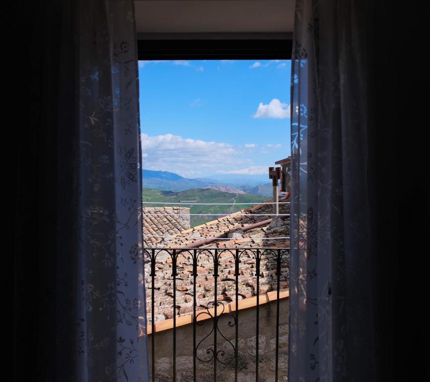 una finestra aperta con vista su un tetto di Casa Vacanze A Tramuntana a Petralia Soprana