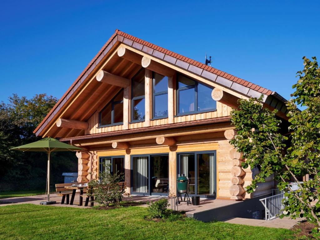 a log house with a picnic table in the yard at Chalet Schwarzwaldchalet de luxe mit Sauna by Interhome in Heitersheim