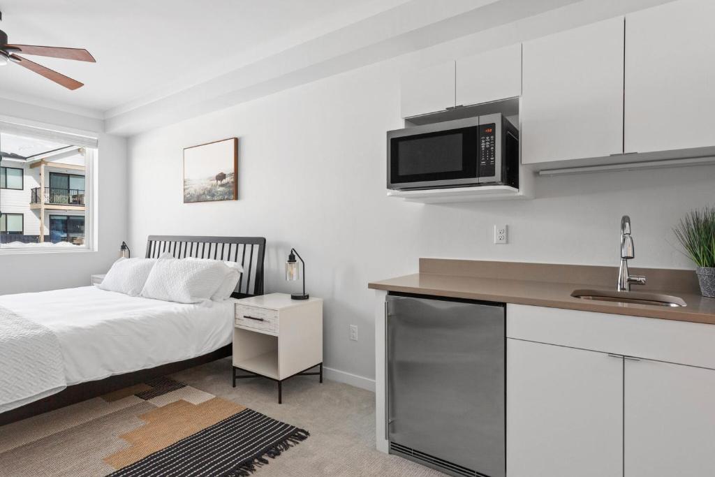 um quarto com uma cama e uma cozinha com um micro-ondas em Perfect Peak, Unit 2B em Fraser