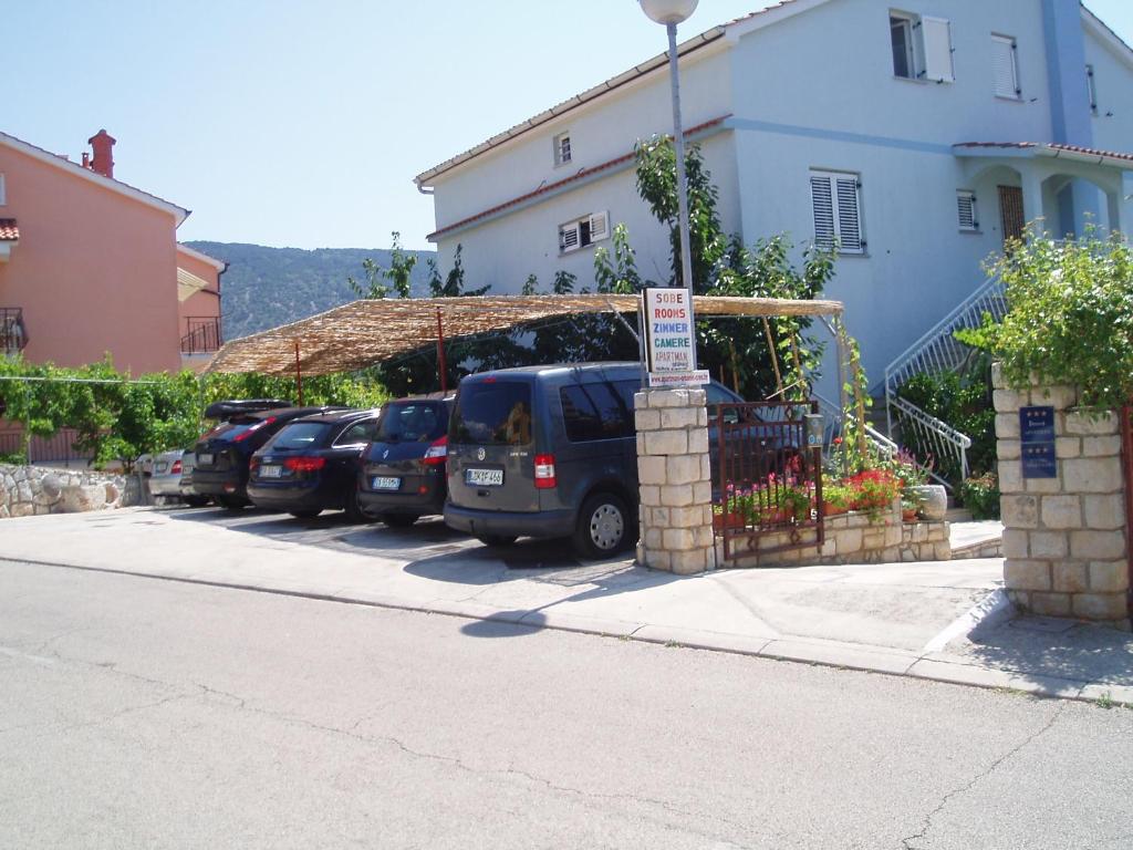 Une rangée de voitures garées sur un parking dans l'établissement Apartment Orbanić Cres, à Cres