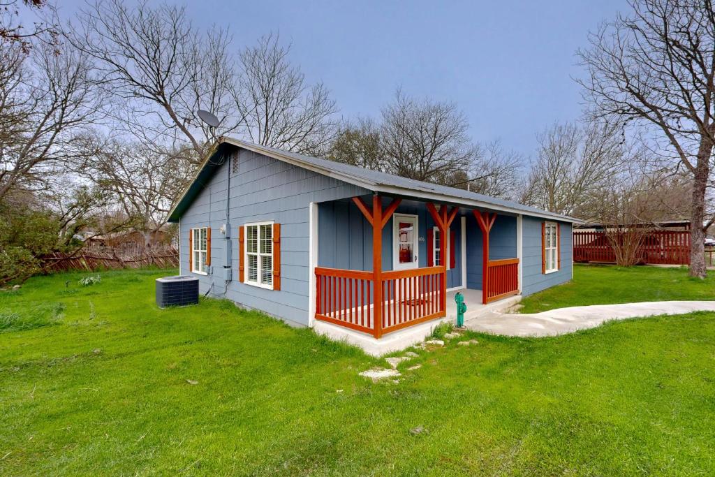 uma pequena casa num quintal com um relvado verde em Cowboy Cottage em Bandera