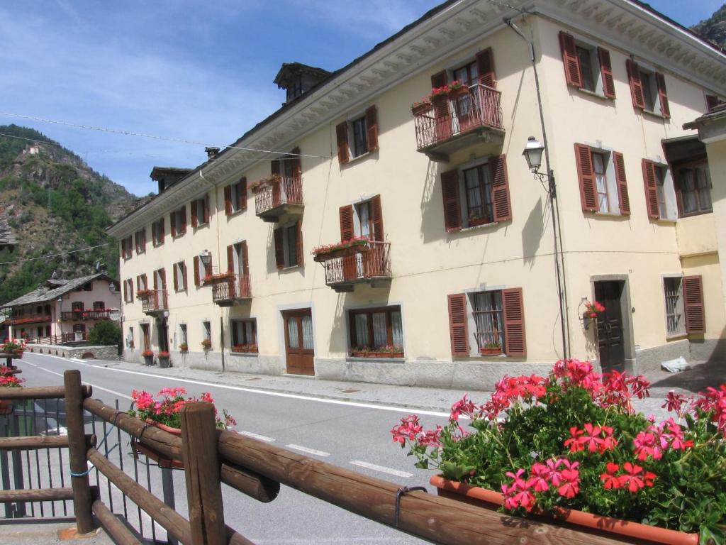 um edifício ao lado de uma rua com flores em Hotel Col Du Mont em Arvier