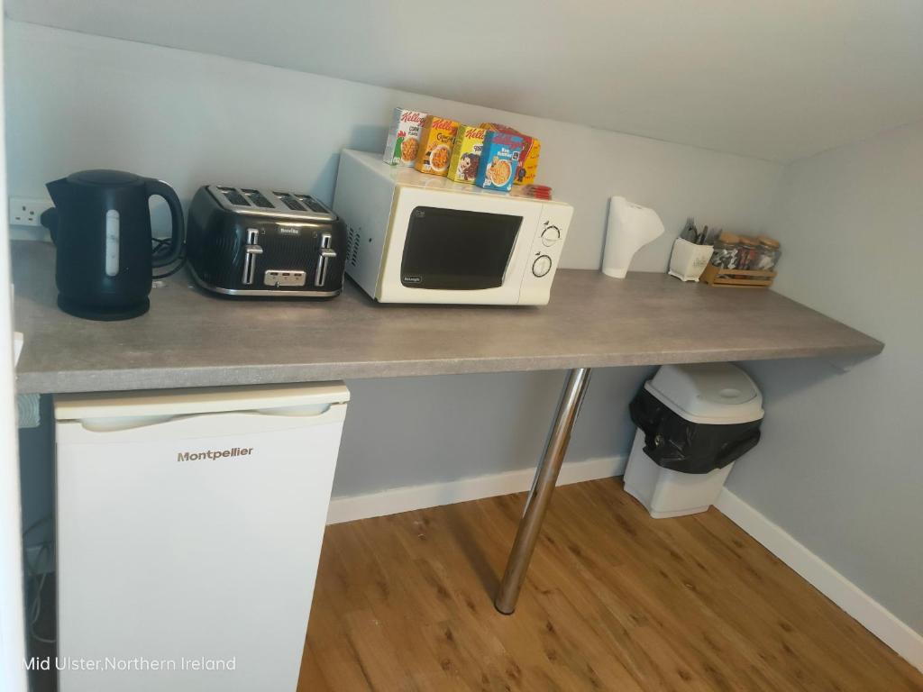 a counter with a microwave and a toaster oven on it at The Oldtown Apartments in Cookstown