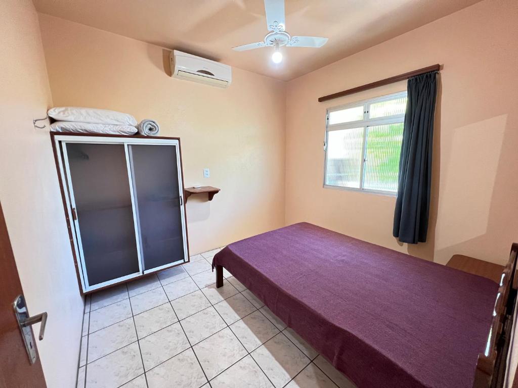 1 dormitorio con cama y ventana en Pousada Residência Nativa, en Pinheira