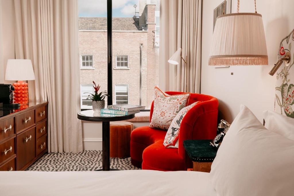 ein Hotelzimmer mit einem roten Stuhl und einem Fenster in der Unterkunft The Leinster in Dublin