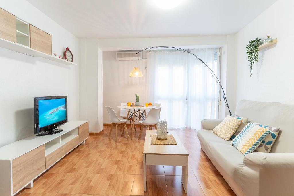 sala de estar con sofá blanco y TV en Trendy Homes Catedral, en Almería