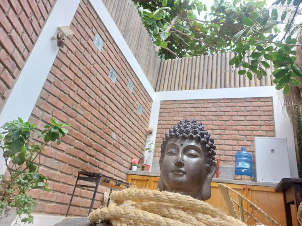 una estatua de una cabeza delante de un edificio de ladrillo en Casita Privada Máncora - Playa & Piscina, en Máncora