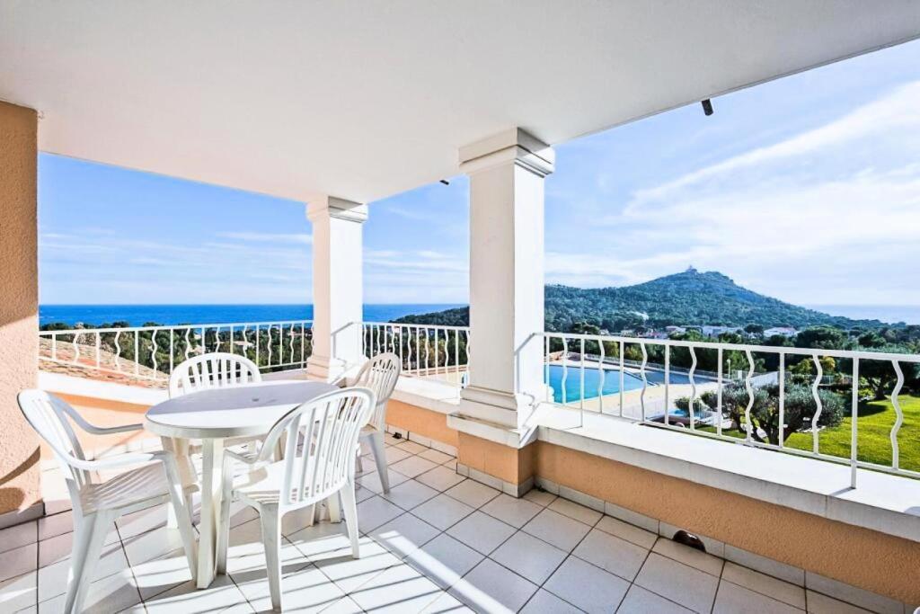 een balkon met een tafel en stoelen en uitzicht op de oceaan bij Résidence le Hameau de Cap Esterel - maeva Home - Studio 5 personnes - Confo 301 in Saint-Raphaël