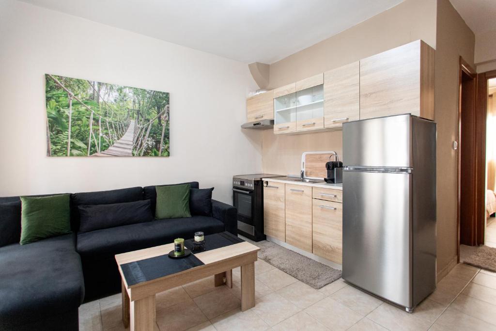 a living room with a couch and a stainless steel refrigerator at Unique Modern Apartment in Alexandroupoli