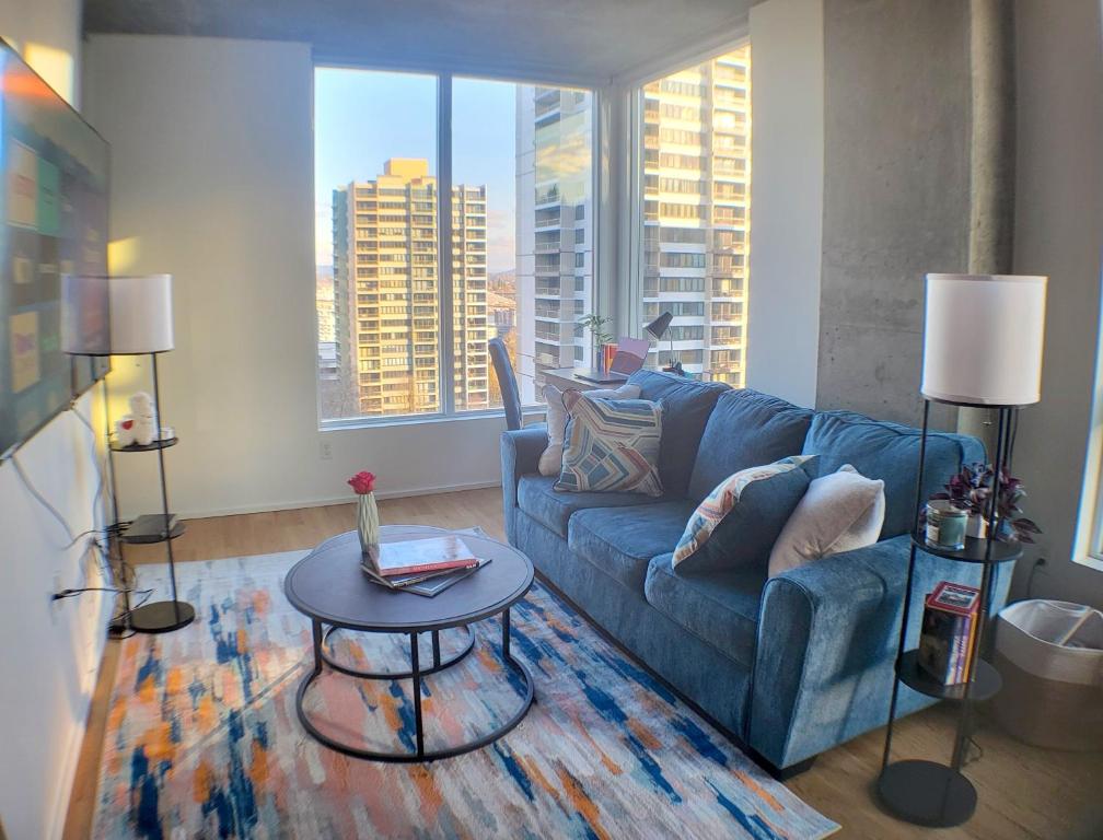 a living room with a blue couch and a table at City Views & Downtown Bliss in Portland