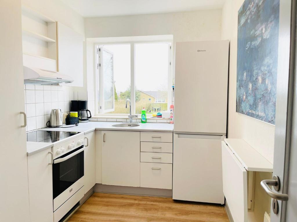 une cuisine avec des appareils électroménagers blancs et une fenêtre dans l'établissement Scandinavian Apartment Hotel- Torsted 1 - 2 room apartment, à Horsens