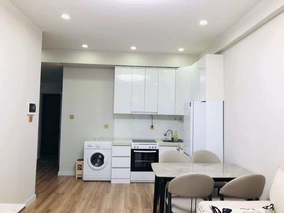 una cocina con electrodomésticos blancos, mesa y sillas en Selbe Apartment "USA Embassy proximity", en Ulán Bator