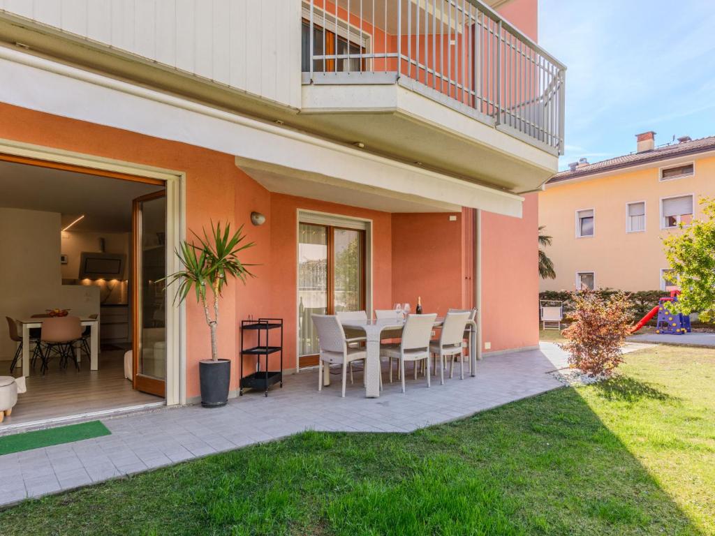 d'une terrasse avec une table et des chaises dans la cour. dans l'établissement Apartment Garden Apartment by Interhome, à Riva del Garda