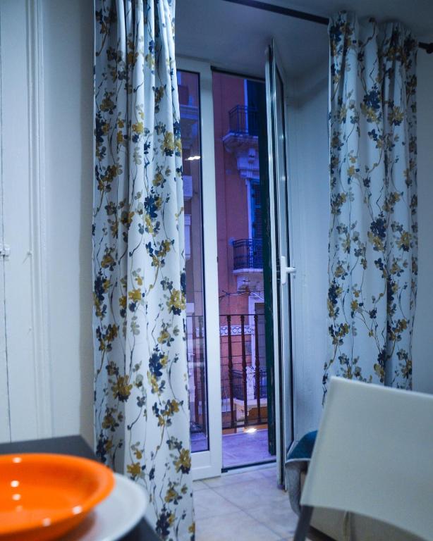 Drzwi otwarte na patio z zasłonami i stołem w obiekcie MANZONI 10 APARTAMENT w mieście Bari