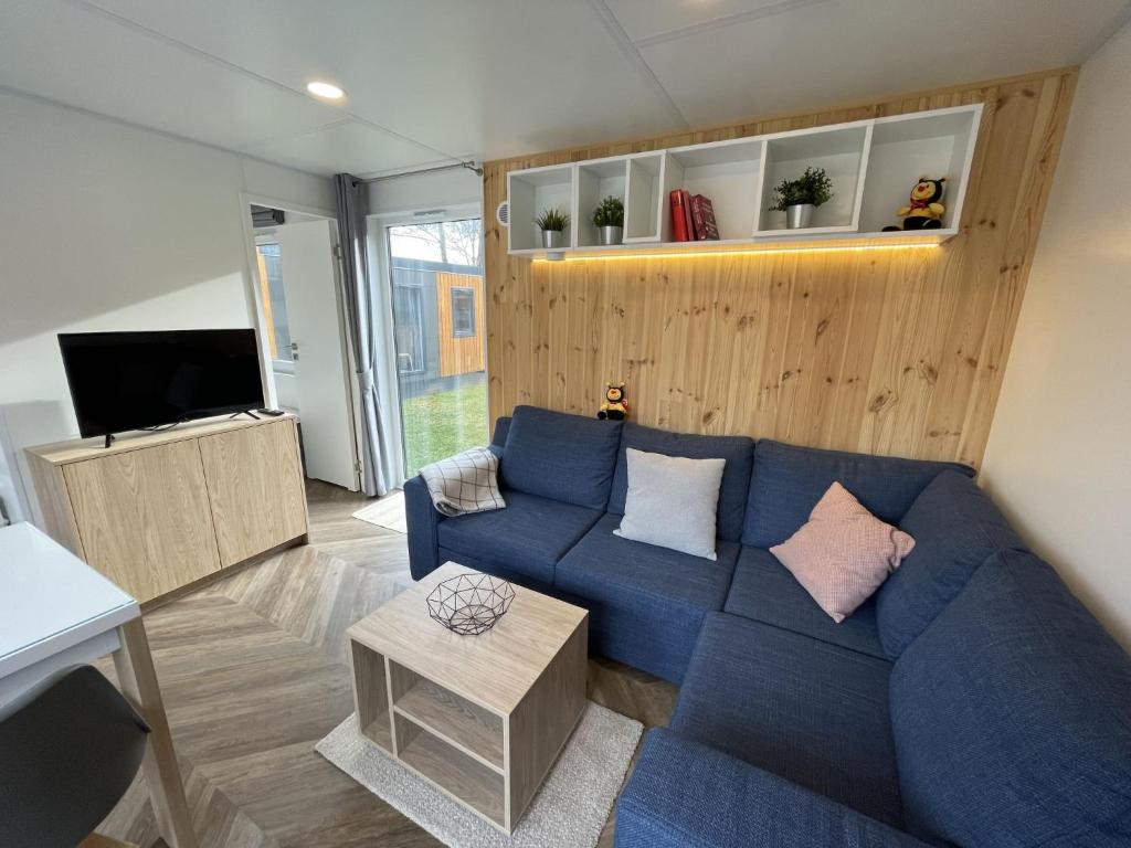 a living room with a blue couch and a tv at Holiday Home Tiny Haus Anellie by Interhome in Riedenburg