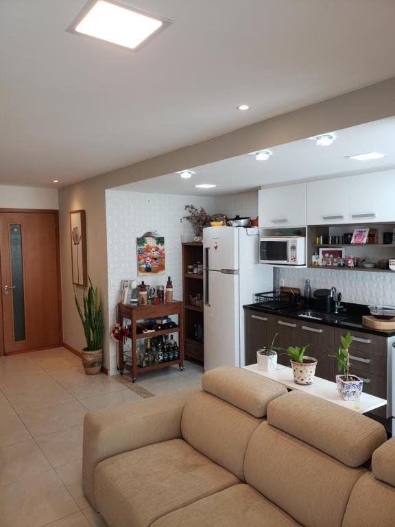 uma sala de estar com um sofá e uma cozinha em Niterói e um pedacinho do Campo em Niterói
