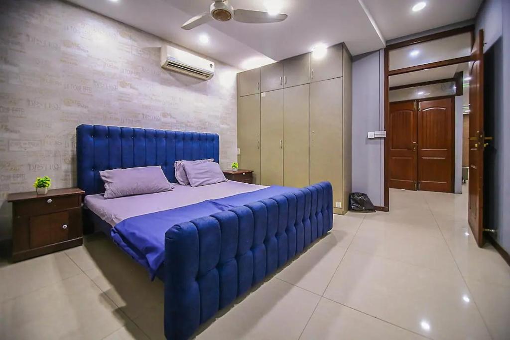 a large blue bed in a room with at Private 2BD Apartment Opposite Dha Phase 8 in Lahore